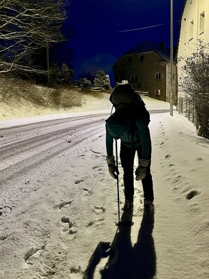 Osoba spiąca na stojąco oparta na kijkach trekkingowych w zimowej, nocnej scenerii (c) Łukasz Derkacz