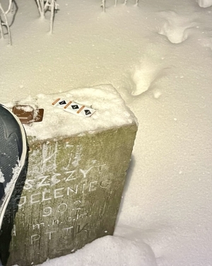 Czekoladka i ciasteczko położone na kamieniu szczytowym, w nocy, w śniegu (c) Łukasz Derkacz