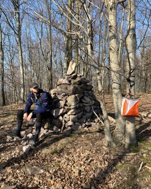 Lasami siedzący w lesie patrzący na lampion do zawodów na orientację (c) Łukasz Derkacz