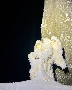 Figurka anioła pokryta zmarzniętymi płatkami śniegu oświetlona światłem latarki (c) Łukasz Derkacz